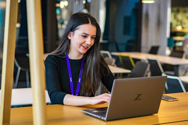 Professional working on a laptop in a bright modern workspace.